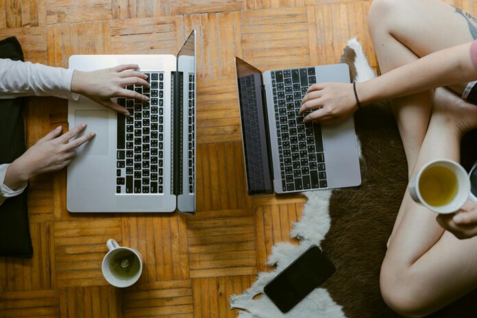 crop women working remotely on laptops in living room